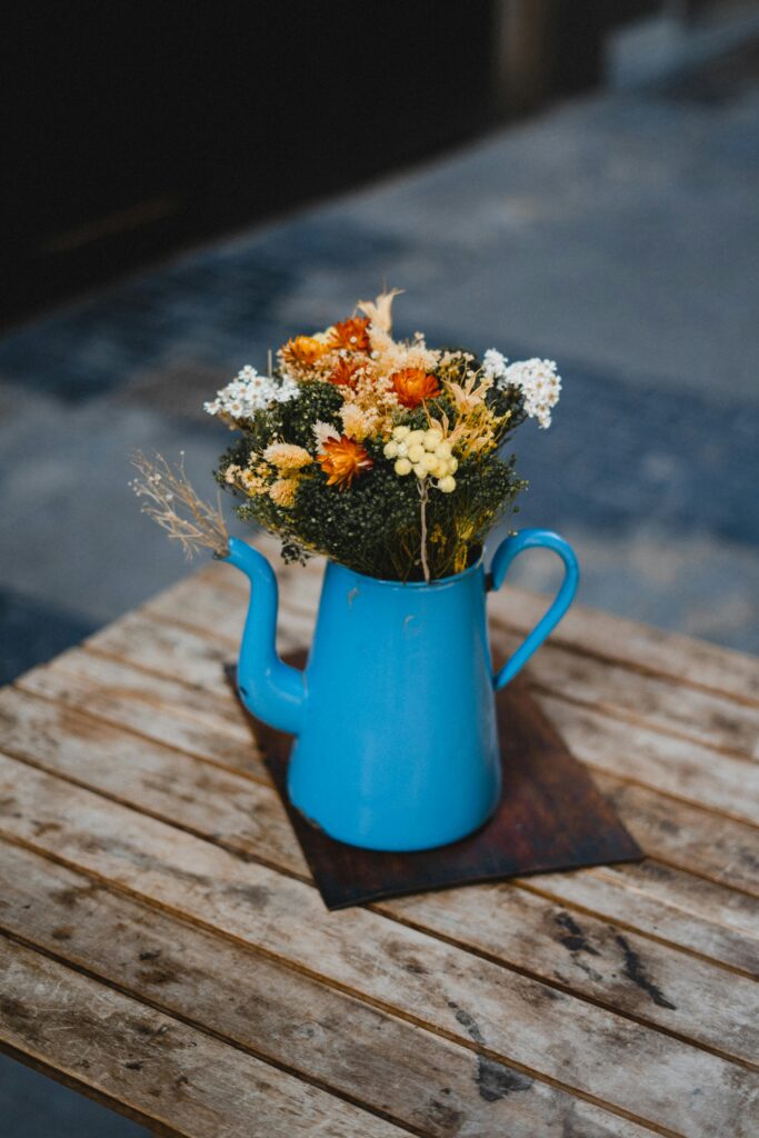 pexels-photo-3409511-3409511 Stylish bouquet of dried flowers in a blue pitcher on a wooden table.